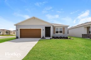Bartow house for rent - a white house with a garage door and a lawn