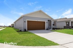 Bartow house for rent - a white house with a garage door and a lawn
