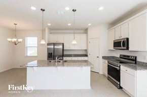 Bartow house for rent - a kitchen with white cabinets and granite counter tops