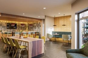 Brookline apartment for rent - a dining area with a wooden table and chairs and a bar with yellow chairs