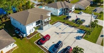 Cape Coral apartment for rent - A parking lot with several cars and a building in the background.
