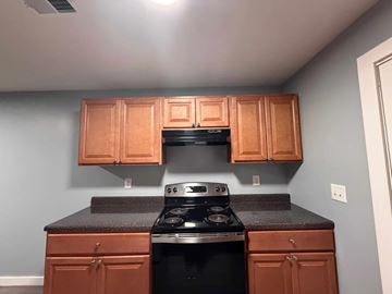 East Point apartment for rent - A kitchen with wooden cabinets and a black stove top.