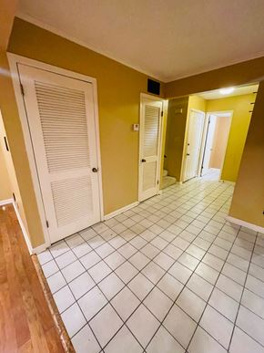 Lafayette house for rent - A hallway with a white tiled floor and a white door.