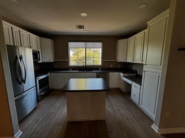 Phoenix apartment for rent - an empty kitchen with white cabinets and black counter tops