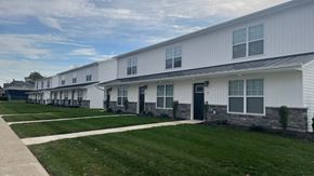 Lima apartment for rent - a row of white houses with grass and a sidewalk