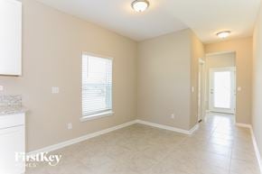 Yulee house for rent - an empty dining room with a door to a hallway and a window