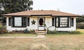 Midwest City house for rent - A white house with a brown roof and a star on the front door.
