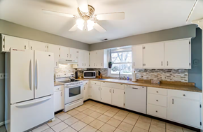 Elida house for rent - A kitchen with white appliances and cabinets.