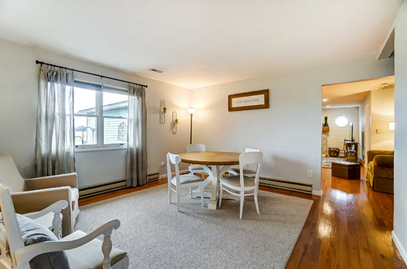 Elida house for rent - A living room with a grey carpet and white chairs.