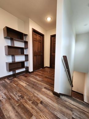 Elida apartment for rent - a living room with a wooden floor and a hallway with wooden shelves