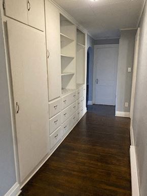 Lima house for rent - a hallway with white cabinets and drawers and a wooden floor