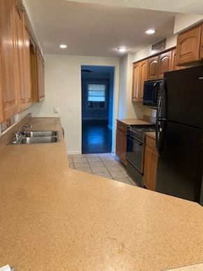 Lima house for rent - a kitchen with a black refrigerator and a sink