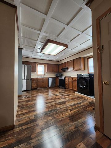 Lima house for rent - an empty kitchen with wooden floors and cabinets and a window