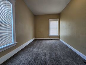 Lima house for rent - an empty room with a window and carpet