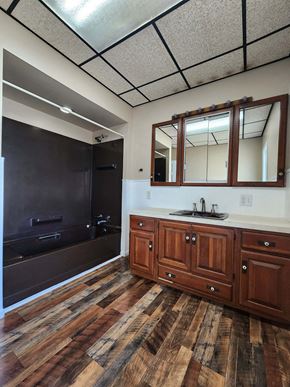 Lima house for rent - a large bathroom with a large black shower and wooden floors