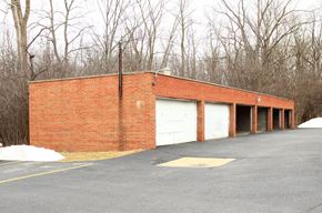Bedford apartment for rent - a brick building with white garage doors in a parking lot