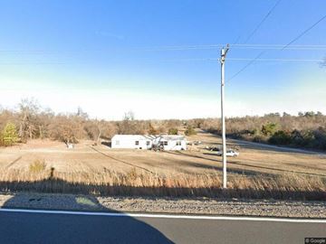 Harrah house for rent - a view of a field with a road and a house