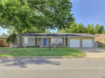 Oklahoma City house for rent - a white house with a yard and a tree