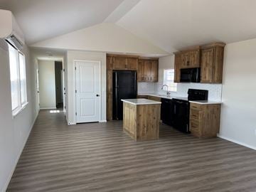 Shawnee house for rent - A kitchen with wooden cabinets and black appliances.