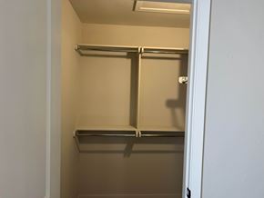 Shawnee house for rent - A small, empty pantry with a metal shelf and a white door.