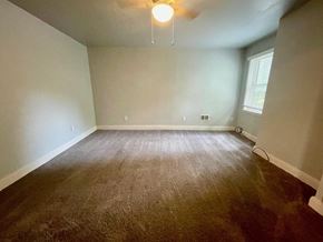 New Albany apartment for rent - a empty living room with a carpeted floor and a ceiling fan