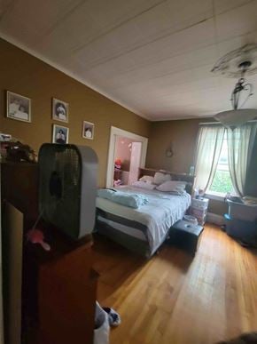New Glasgow apartment for rent - A bedroom with a bed, dresser, and ceiling fan.