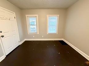 New Albany apartment for rent - A room with a white door and two windows with white blinds.