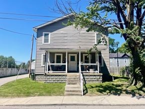 New Albany apartment for rent - A house with a grey facade and a green lawn.