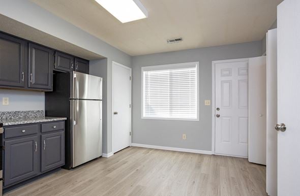 Ontario apartment for rent - A kitchen with a refrigerator, cabinets, and a window.