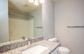 Ontario apartment for rent - A bathroom with a sink, toilet, and mirror.