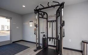 Ontario apartment for rent - A home gym with a squat rack and a bench.