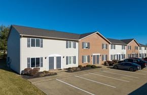 Ontario apartment for rent - A parking lot in front of a white and brick building.