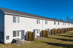 Ontario apartment for rent - A long white building with a grey roof and a blue sky in the background.