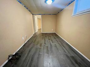 New Albany apartment for rent - A long, narrow room with wooden flooring and a window on the right side.