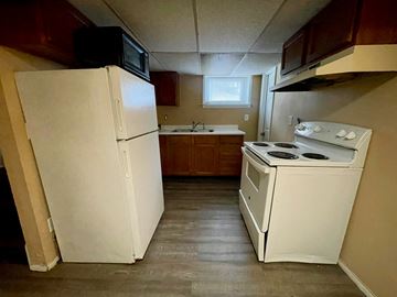 New Albany apartment for rent - A small kitchen with a white refrigerator and a white stove top oven.