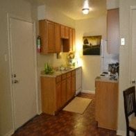 Bossier City apartment for rent - a small kitchen with wooden cabinets and a door