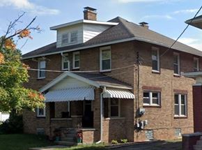 Lima apartment for rent - A two-story brick house with a white roof and a covered porch.