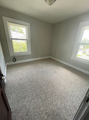 Lima apartment for rent - A room with a carpet floor and two windows.