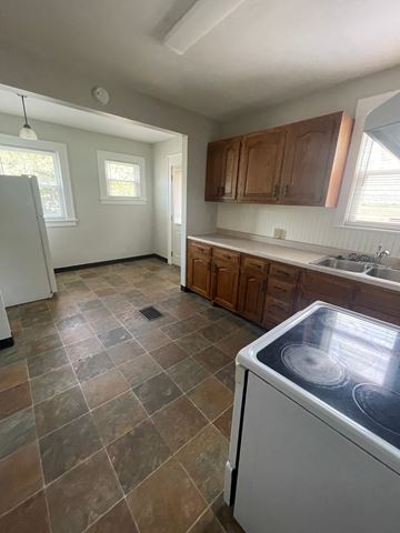Lima apartment for rent - A kitchen with a white dishwasher and brown cabinets.