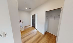Oshkosh townhouse for rent - a bedroom with a door to a closet and a hallway with wood flooring