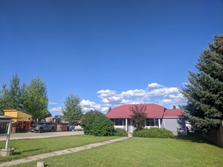 Driggs apartment for rent - a house with a red roof and a lawn and trees