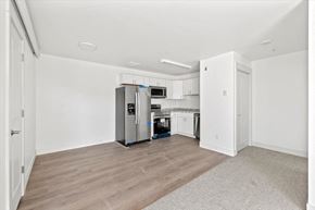 Driggs apartment for rent - an empty living room with a kitchen with a refrigerator