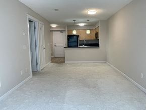 Edmonton apartment for rent - an empty living room with a kitchen in the background