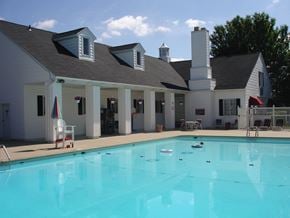 Fort Wayne townhouse for rent - a swimming pool in front of a white house with a large pool