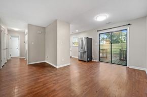 Jacksonville house for rent - A spacious room with wooden floors and a refrigerator.