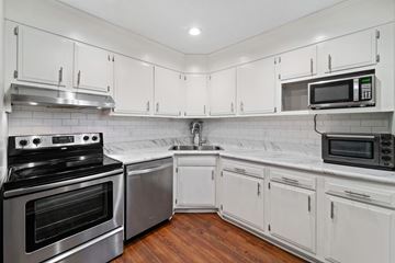 Jacksonville house for rent - A kitchen with white cabinets and stainless steel appliances.