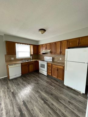Cridersville apartment for rent - an empty kitchen with white appliances and wooden cabinets