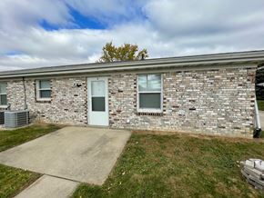 Cridersville apartment for rent - an old brick building with a blue door and a driveway