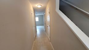 Lima apartment for rent - a long hallway with a staircase and a door to a room with a door open