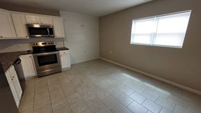 Lima apartment for rent - an empty kitchen with white cabinets and stainless steel appliances